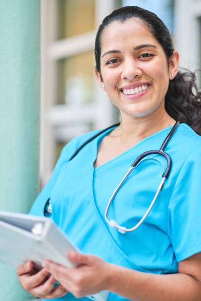 istock Young latin nurse with stethoscope holding a binder clip 1218308459