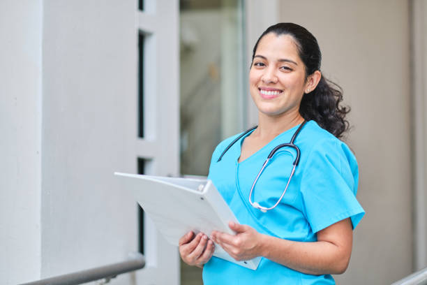 istock Young latin nurse with stethoscope holding a binder clip 1218308578