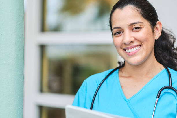 istock Young latin nurse with stethoscope holding a binder clip 1218308809