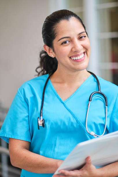 istock Young latin nurse with stethoscope holding a binder clip 1218309417