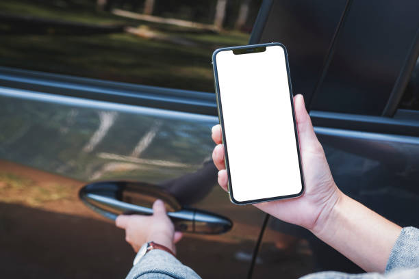istock a woman holding and using mobile phone with blank screen while opening the car door 1218309518