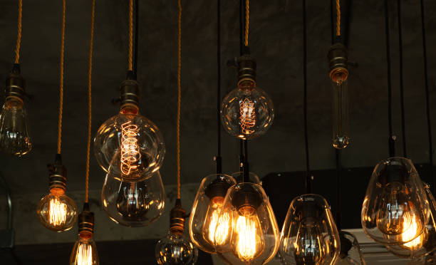 istock Beautiful vintage luxury light bulb hanging decor glowing in dark. 1218314106