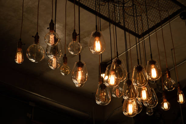 istock Beautiful vintage luxury light bulb hanging decor glowing in dark. 1218314115