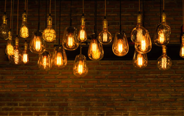 istock Beautiful vintage luxury light bulb hanging decor glowing in dark. 1218314139