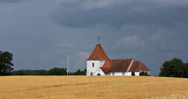 istock Summer landscape with a church in denmark 1218315993