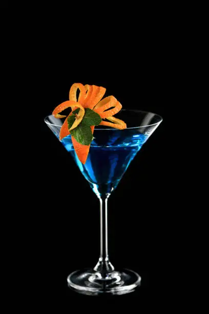 Decoration for a cocktail of orange and mint. Elegant and original presentation. Martini Blue Curacao on a black background