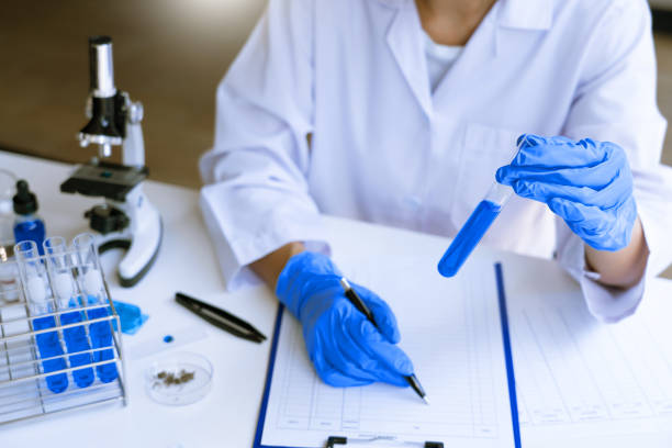 istock scientists researching in laboratory in white lab coat, gloves analysing, looking at test tubes sample, biotechnology concept. 1218321848