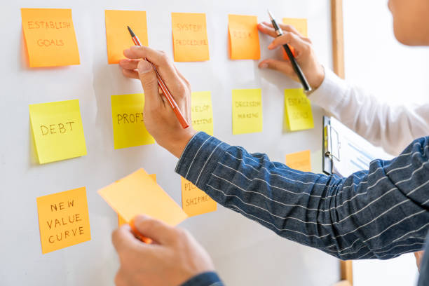 istock young business workers posting with sticky notes stickers reminders  creative brainstorming at board the colleague in a modern co-working space 1218321849