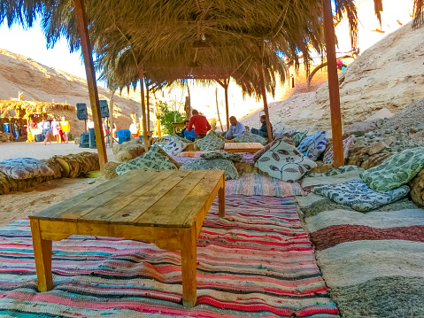 Sharm El Sheikh, Egypt - February 17, 2020: The people at lounge and relax area at bedouin village in Sahara desert on mountain landscape at Dahab