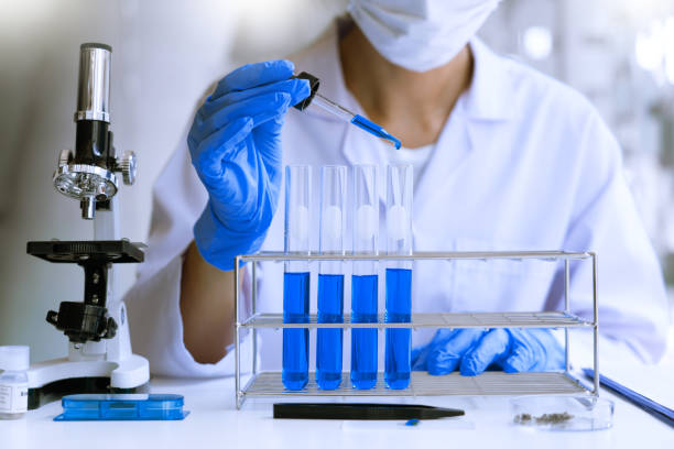 istock scientists researching in laboratory in white lab coat, gloves analysing, looking at test tubes sample, biotechnology concept. 1218322912
