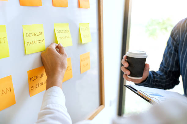 istock young business workers posting with sticky notes stickers reminders  creative brainstorming at board the colleague in a modern co-working space 1218322993
