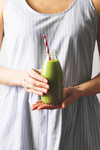 istock Female hands holding a bottle with green smoothie 1218331752