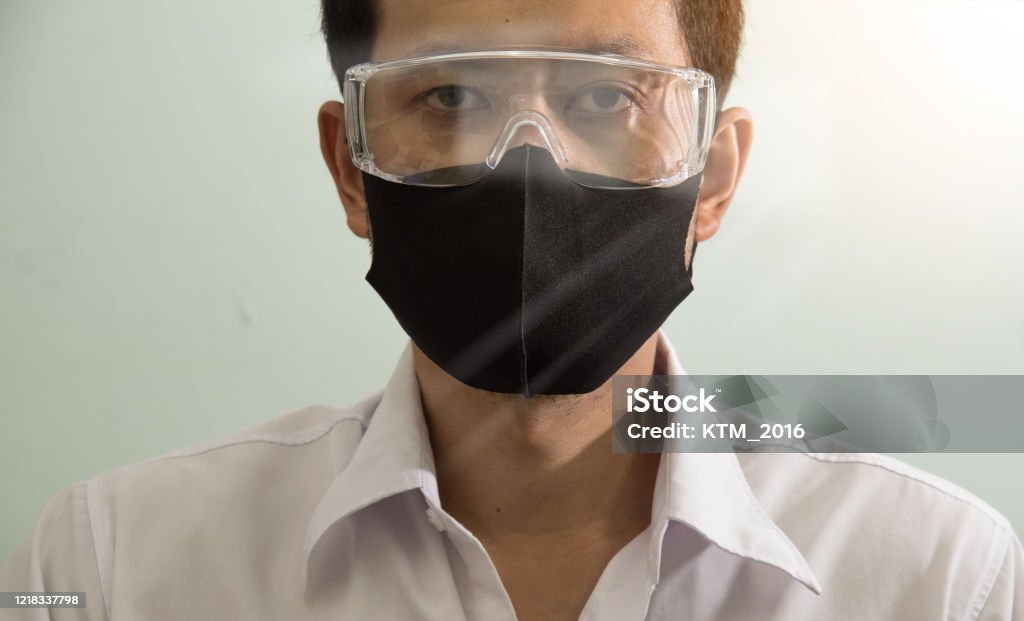 Businessman wearing safety google and mask to protect virus COVID-19. Stay home, Work from home, Social Distance Concept. Adult Stock Photo