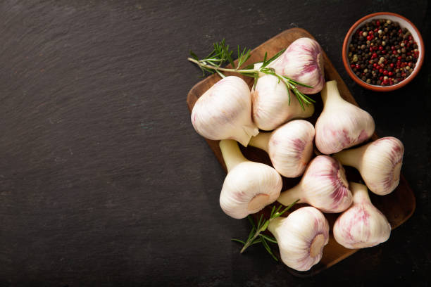 istock Fresh garlic bulbs with rosemary and pepper, top view 1218337996