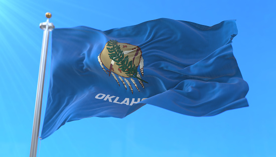 Flag of american state of Oklahoma, region of the United States, waving at wind