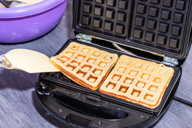 istock Cooking home Belgian waffles in an electric waffle iron. 1218342721