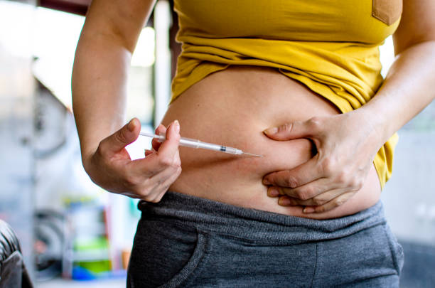Trying hard to be a Mother Woman making hormonal therapy injection into her belly. Close up syringe pen. Person in vitro fertilisation treatment injecting hormone for pregnancy. in vitro fertilization photos stock pictures, royalty-free photos & images
