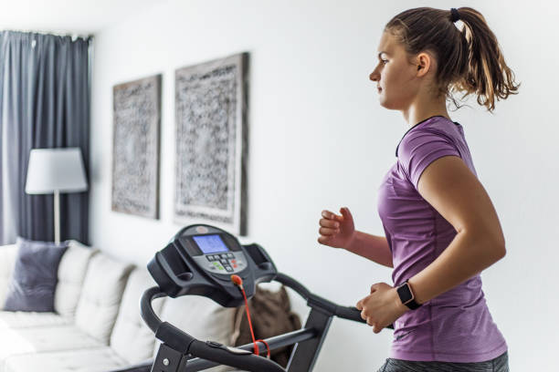 home gym per ragazza adolescente bruna su un tapis roulant - beautiful caucasian teenager running foto e immagini stock