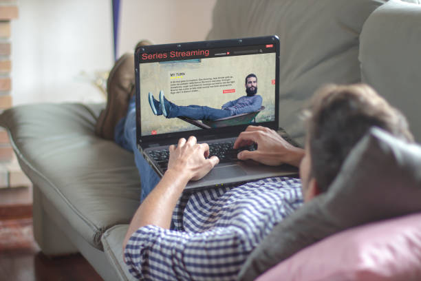 istock Young man watching series streaming on laptop screen 1218352128