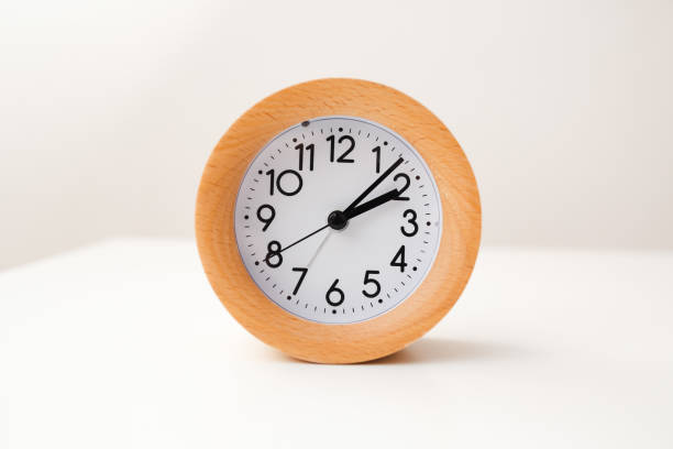 istock Wooden alarm clock on white table background 1218355729
