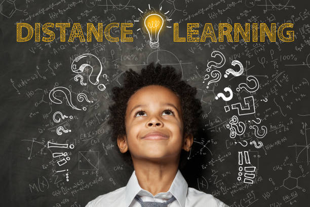 istock Distance learning. Black child boy with idea light bulb, question marks and science formulas 1218358567