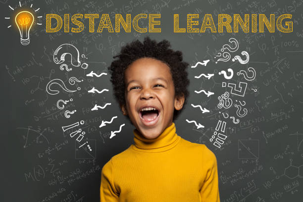 istock Distance education. Black child student with idea light bulb, question marks and science formulas 1218358578