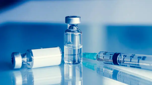 Photo of Vaccine vial dose flu shot drug needle syringe,medical concept . blue background. selection focus.