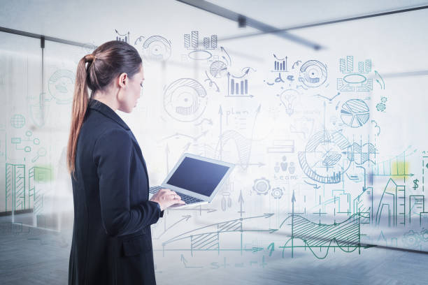 istock Woman with laptop and business plan in office 1218362145