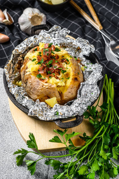 istock baked potatoes with bacon, green onion and cheese. White background. Top view. 1218365237
