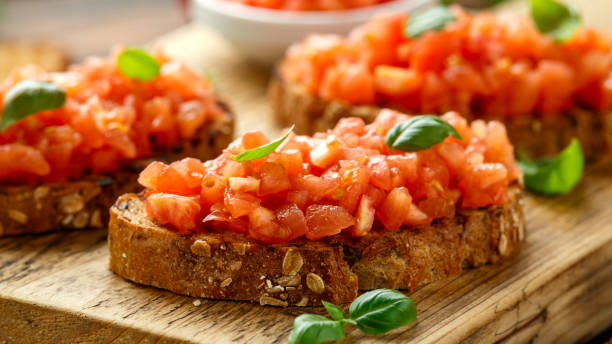 istock Tomato bruschetta seasoned with basil on a rustic wooden board 1218366694