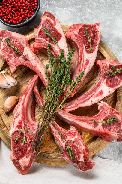 istock Rack of lamb , raw meat with bone, chops with salt, pepper. Gray background. Top view 1218367657