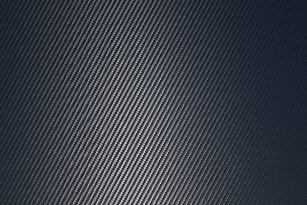 istock Grey woven carbon fibre sheet surface with light reflection. 1218368602