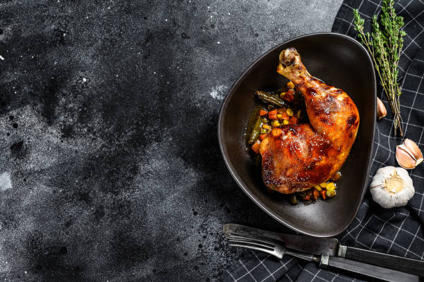istock Cooked roasted chicken legs. Grilled meat. Blacked background. Top view. Copy space 1218369720