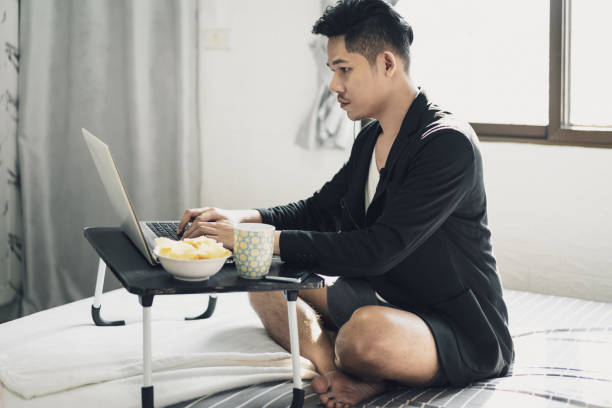 Businessman sit on the bed doing work from home