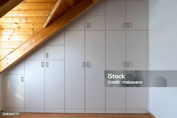 Interior View Of A Custommade Closet Built Into A Master Bedroom With A Sloping Roof Stock Photo - Download Image Now