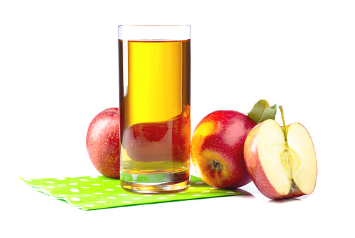 Glass of apple juice with apples isolated on a white background.
