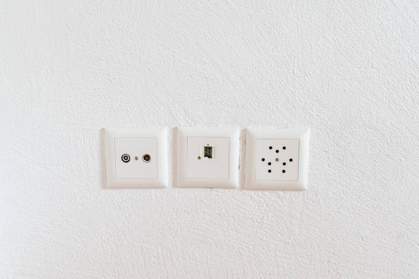 vista de cerca de los enchufes para televisión, internet, teléfono y electricidad en una pared blanca - paling fotografías e imágenes de stock