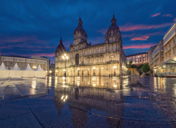 A Coruna, Spain. View of Praza de Maria Pita A Coruna, Spain. View of Praza de Maria Pita square with building of City Hall reflecting in puddle at dusk a coruna province stock pictures, royalty-free photos & images