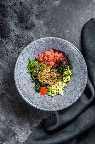 miska z tuńczyka z wodorostami, awokado, ogórkiem, rzodkiewką, sezamem. czarne tło. widok z góry - salmon food carpaccio avocado zdjęcia i obrazy z banku zdjęć