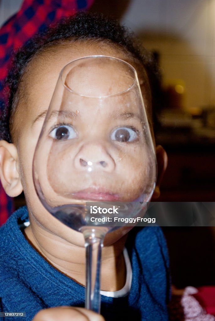 Beautiful large eyes behind a wine glass Child Stock Photo