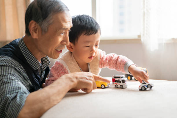 family Grandfather and grandson play games in the living room china chinese ethnicity smiling grandparent stock pictures, royalty-free photos & images