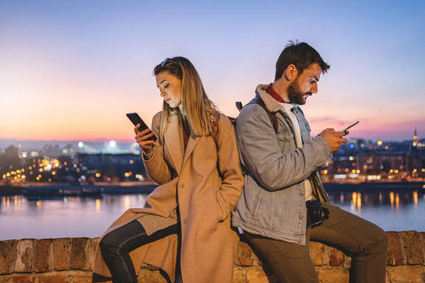 istock Traveling couple with relationship difficulties sitting on a for wall back to back 1218373643