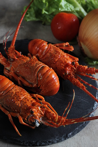 Three cooked sea lobsters on stone plate. Red and delicious