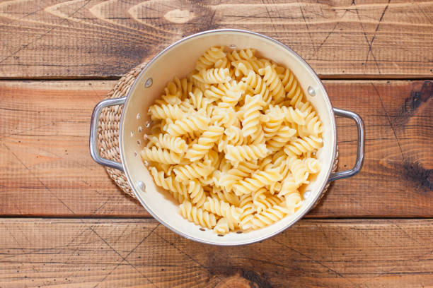 istock Step by step cooking pasta casseroles with eggs, step 2 - boiled pasta in a colander, top view, selective focus 1218375884