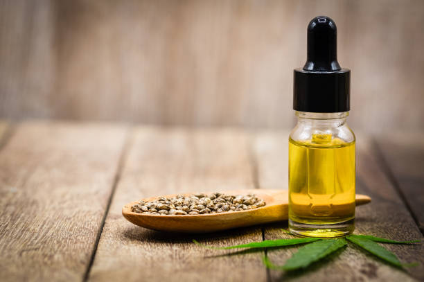 Hemp oil and hemp seeds on a wooden table, Medical marijuana products including cannabis leaf, cbd and hash oil, alternative remedy or medication,medicine concept. Hemp oil and hemp seeds on a wooden table, Medical marijuana products including cannabis leaf, cbd and hash oil, alternative remedy or medication,medicine concept. cbd oil photos stock pictures, royalty-free photos & images