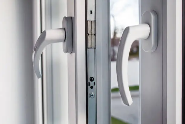 handles of opened white plastic window indoor closeup