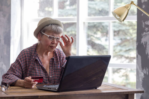 istock Elderly woman with computer and credit card inside. 1218376985