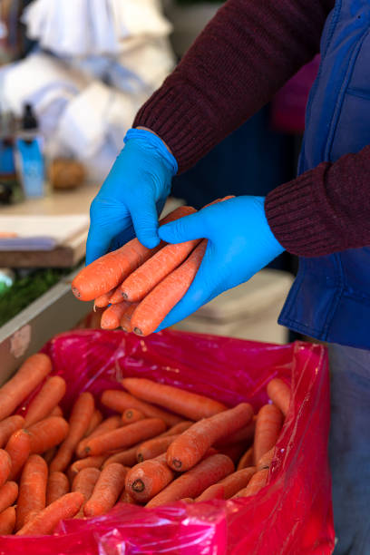 istock Greengrocer holding vegetables with rubber gloves. 1218377267