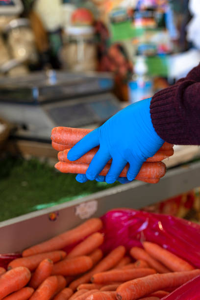 istock Greengrocer holding vegetables with rubber gloves. 1218377469
