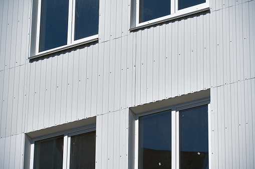 Wall of modern metal industrial building with windows